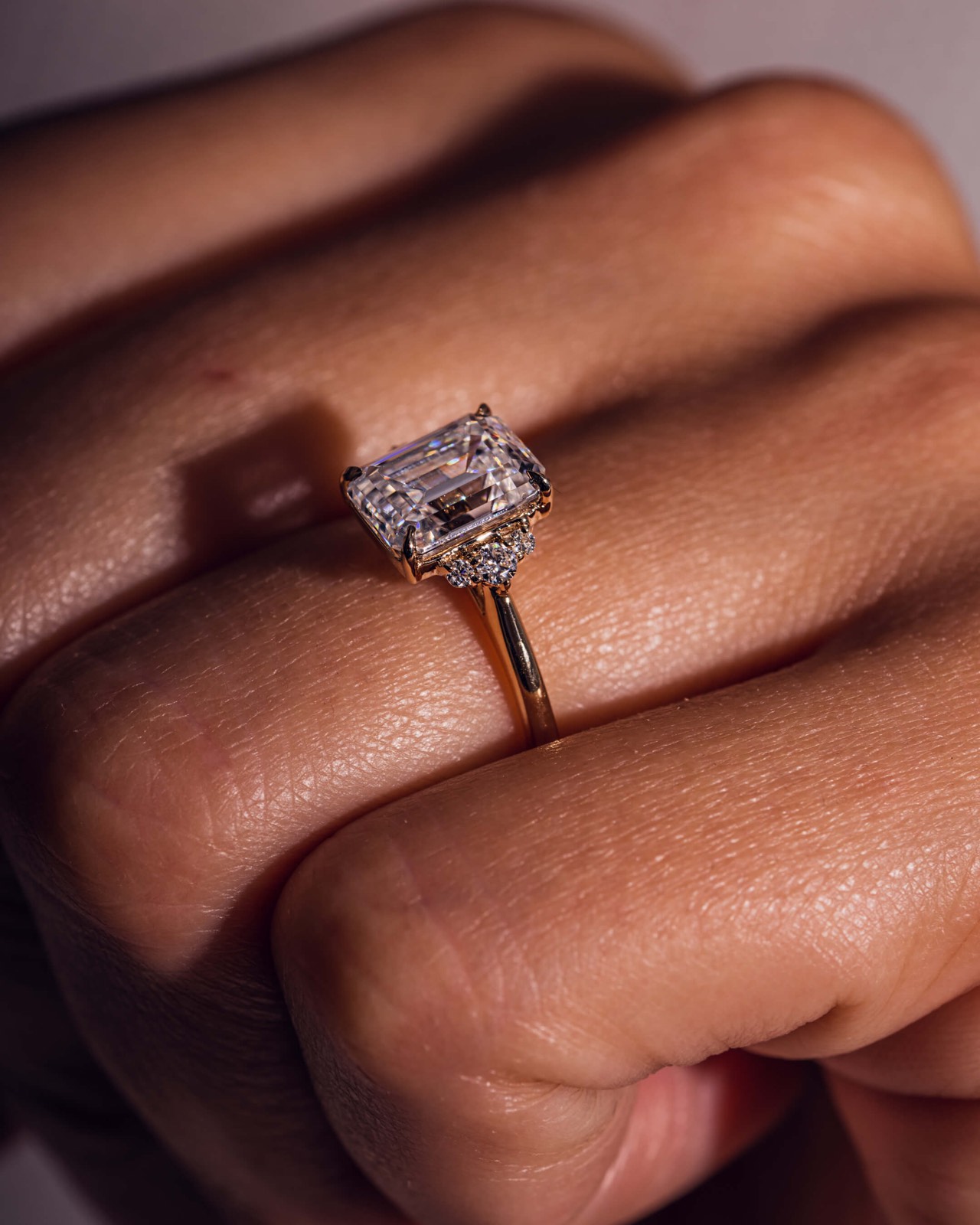 Hand wearing an oval lab-grown diamond solitaire on silk